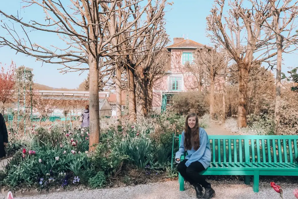 Girl sitting on bench in gardens at Giverny