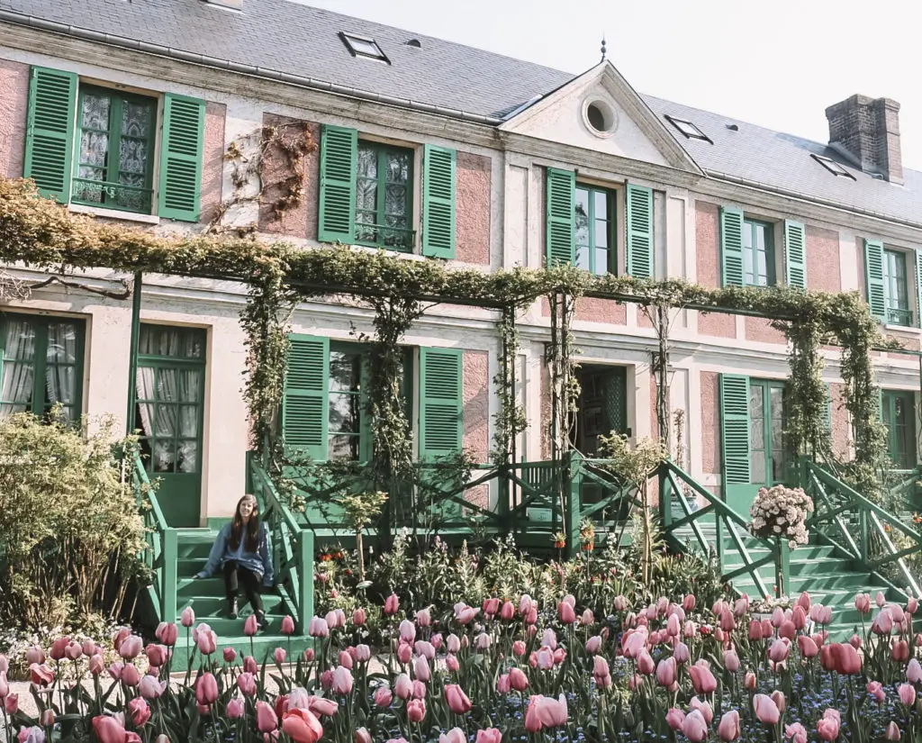 Girl in front of pink Giverny house