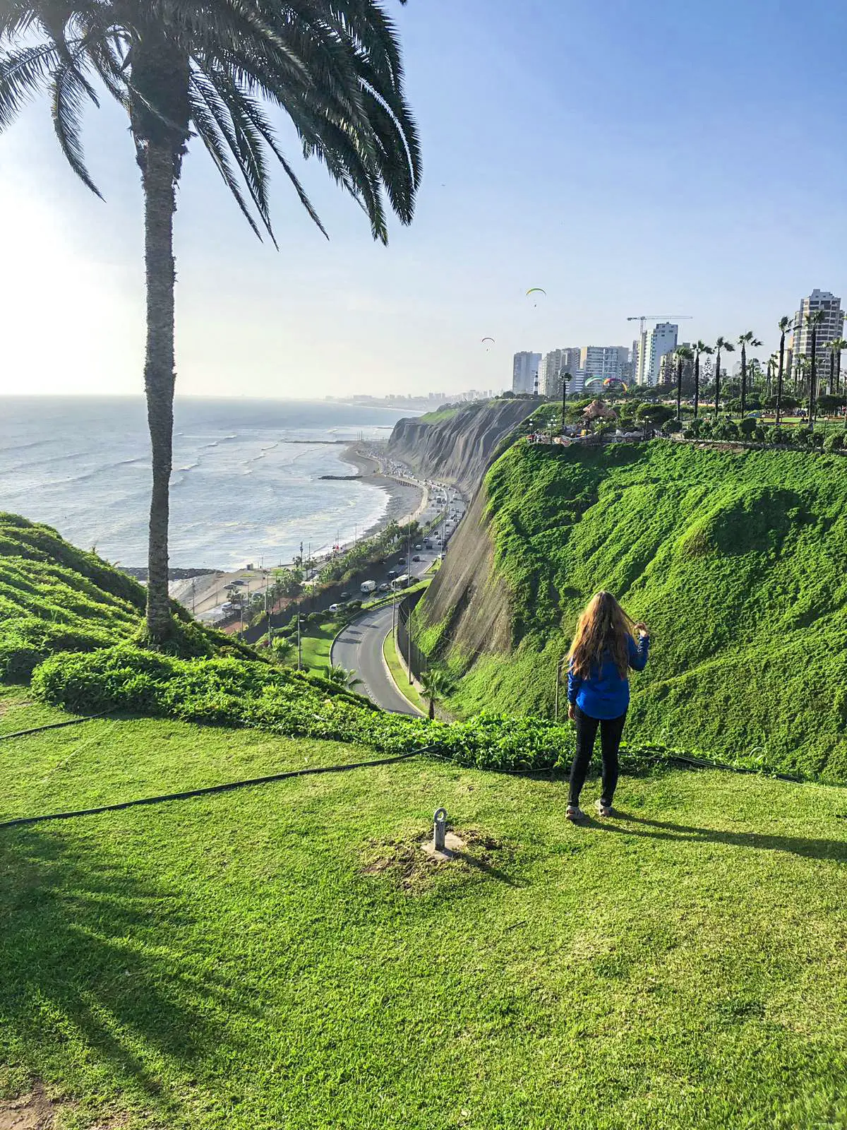 girl in front of cliffs and boardwalk in Lima Peru