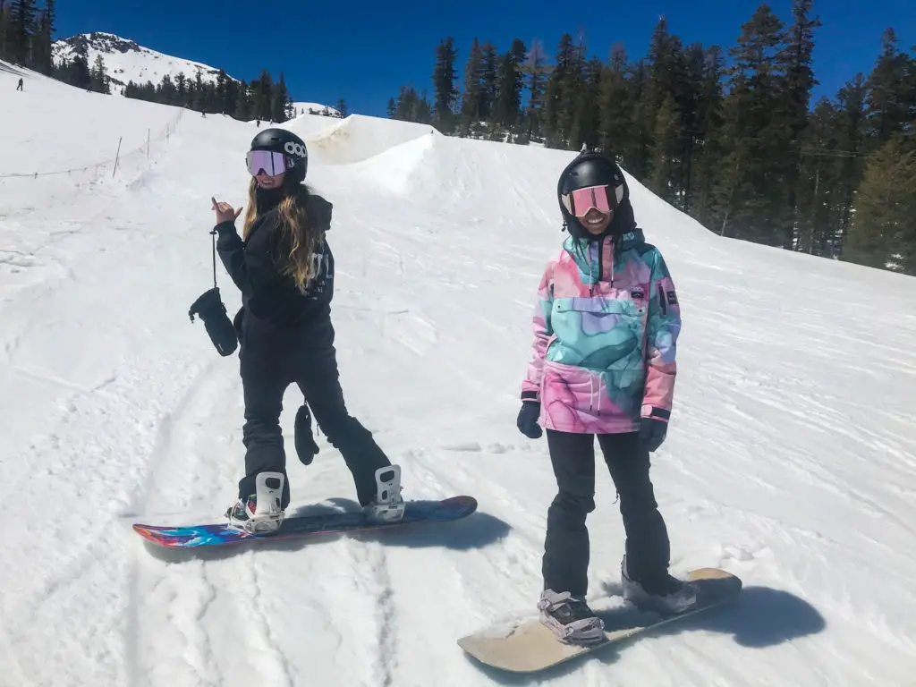 girls in front of large snow jump terrain park 