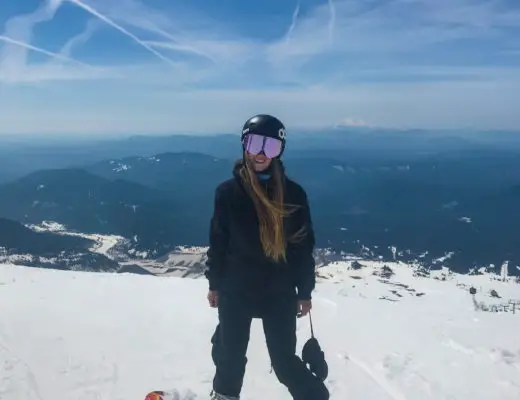 girl on snowboard with mountain view